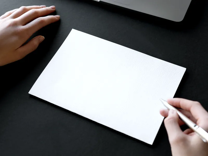 Manos a punto de escribir en una hoja en blanco