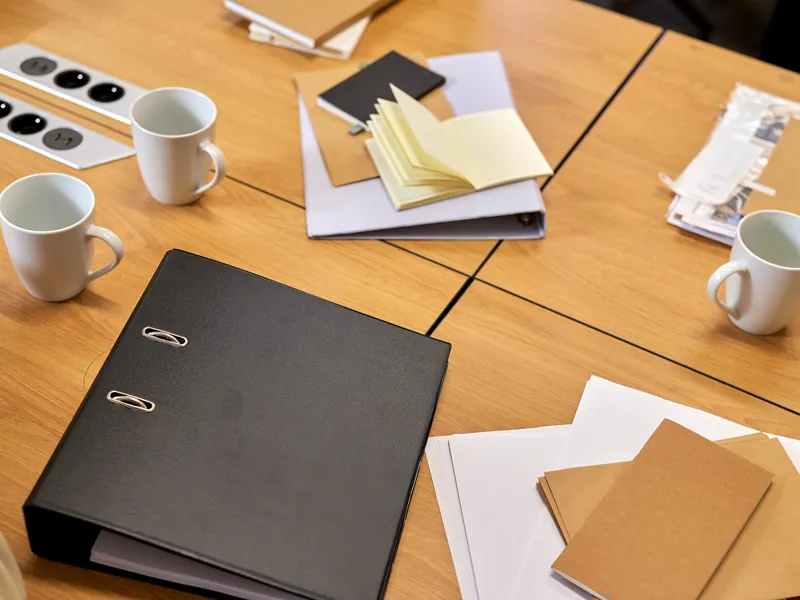 Archivador, carpetas y libretas ordenados sobre una mesa