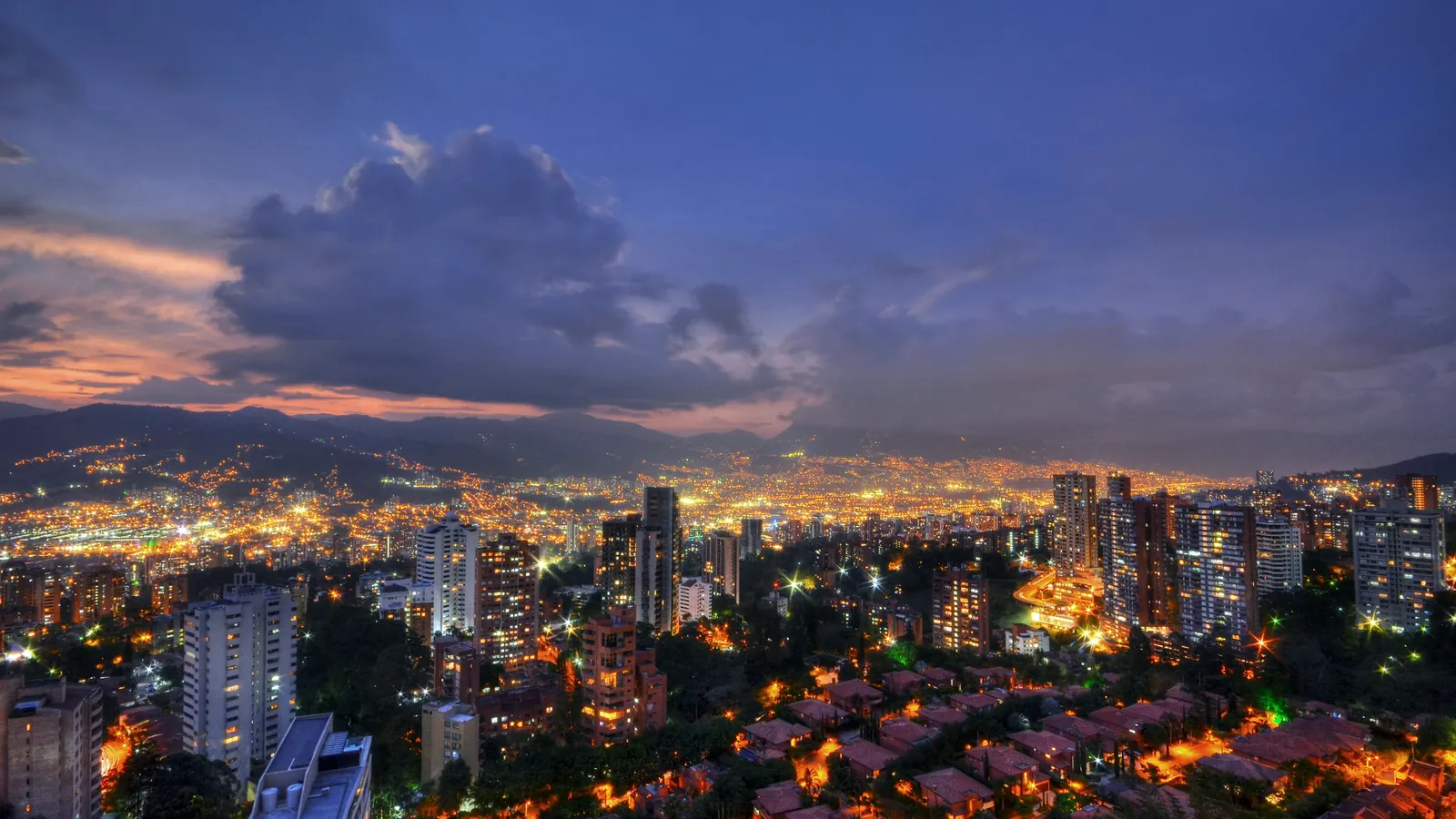 Panorámica de Medellín a la hora azul, con el valle iluminado y las montañas al fondo